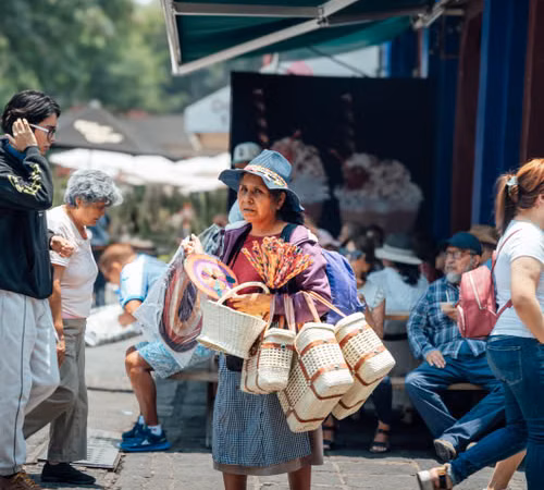 Personas en un espacio de comercio local; imagen editorial sobre visitantes y negocios de fin de semana.