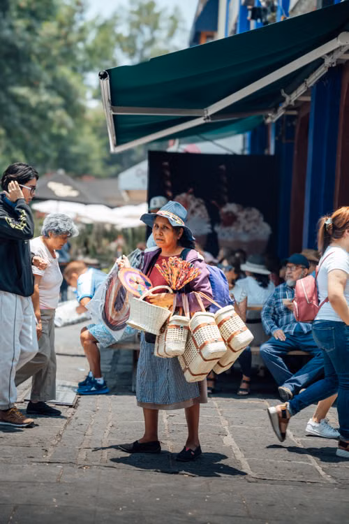 Personas en un espacio de comercio local; imagen editorial sobre visitantes y negocios de fin de semana.